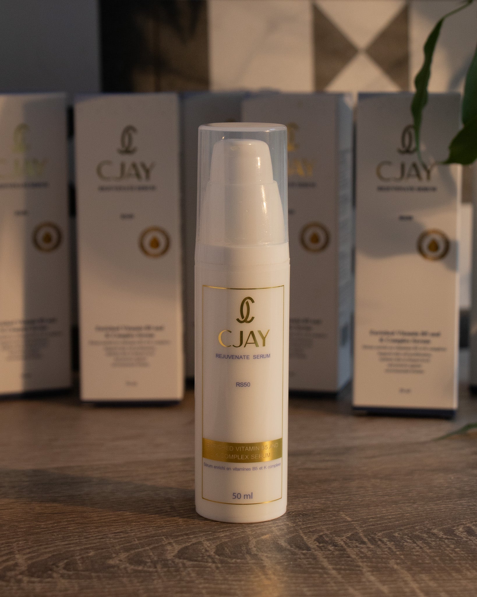 CJAY skincare serum bottle with boxes in the background on a wooden surface