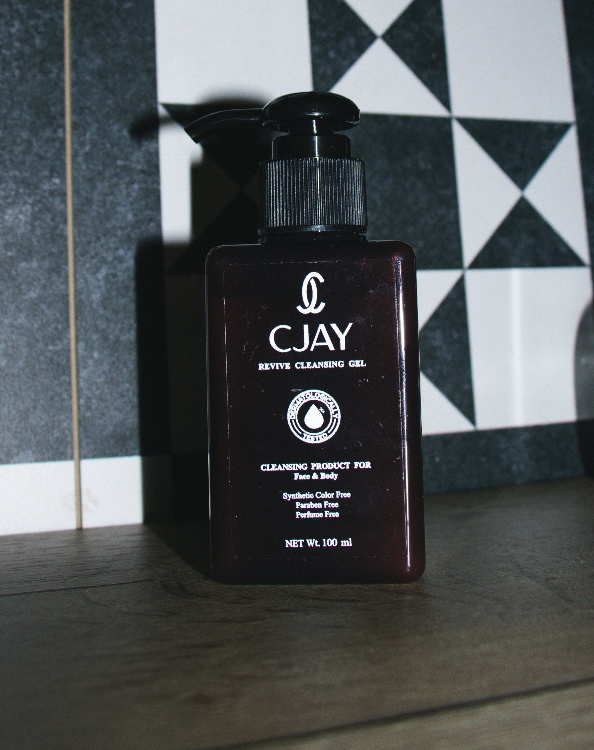 CJAY cleansing gel bottle on a checkered floor